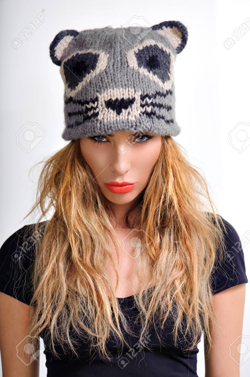 スタイリッシュな黒の T シャツには長い髪と美しい感情的な魅力的な女性のポートレートを白い背景にサインを送る灰色面白いキャップ ポーズを閉じます スタジオ撮影します ファッションを見て の写真素材 画像素材 Image