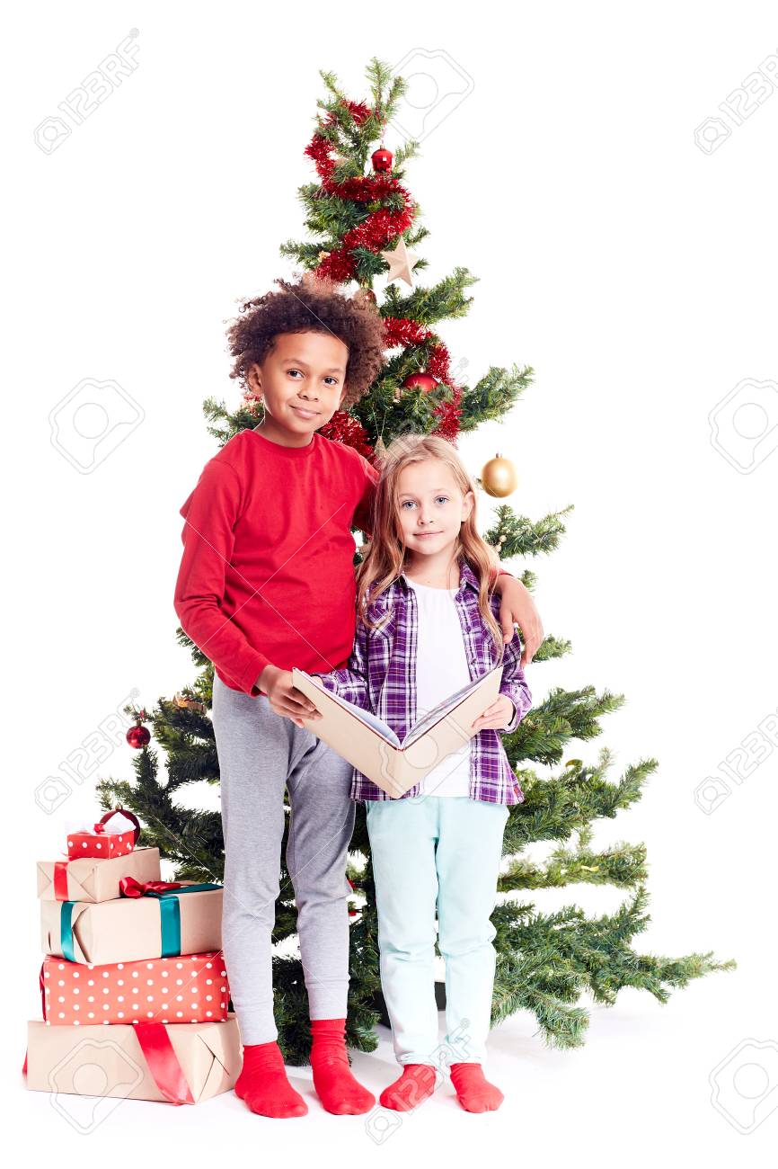 portrait of diverse brother and sister standing near christmas