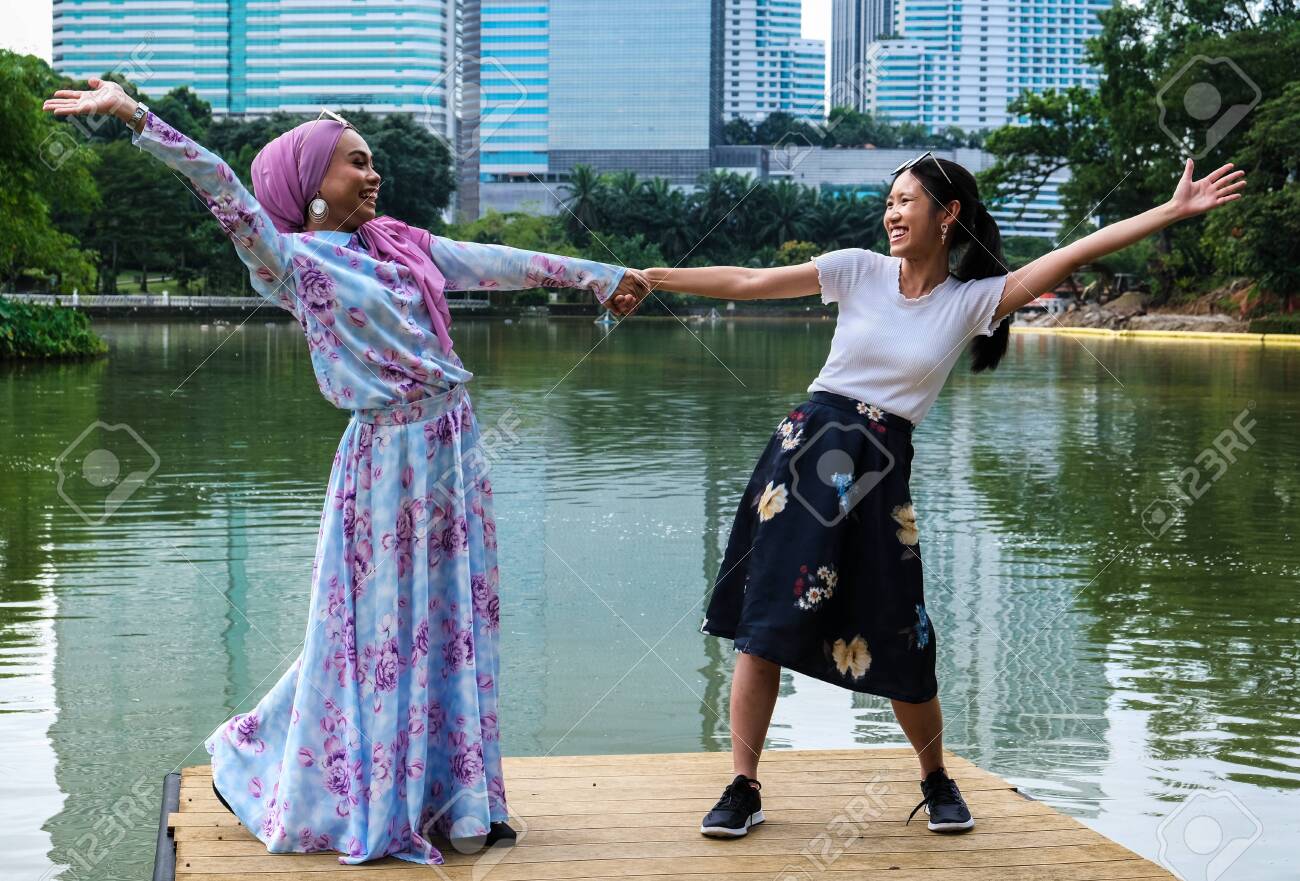 A Malay And Chinese Girl Stretch Out Their Arms In Celebration Of Their Friendship Stock Photo Picture And Royalty Free Image Image 141194248