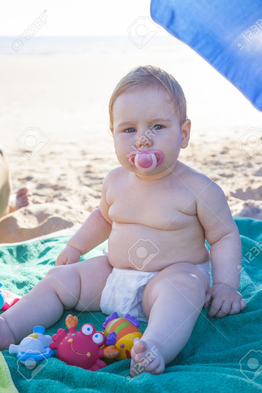 Bebe Avec Couche Blanche Sur Une Serviette Verte Sur La Plage Banque D Images Et Photos Libres De Droits Image