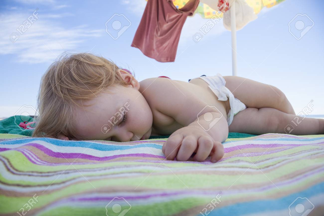 Bebe D Un An Avec Le Blanc Couche Dormir Sur Raye De Couleur Serviette De Plage Sous Un Parasol Banque D Images Et Photos Libres De Droits Image