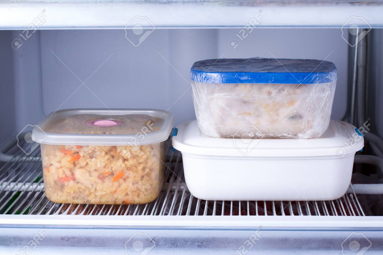 Frozen food in a container in the freezer. Refrigerator with frozen food. Ready meal - 97657890 Frozen food in a container in the freezer. Refrigerator with frozen food. Ready meal - 97657890