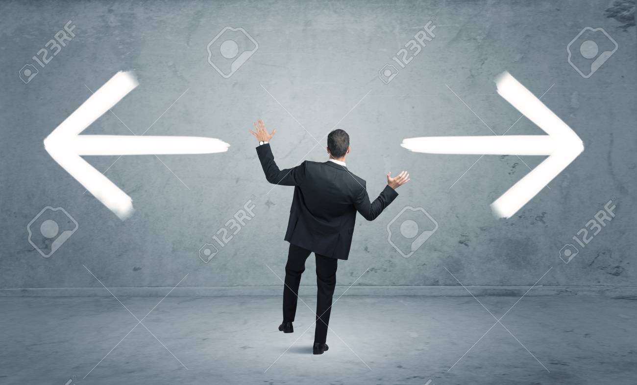 Un Homme D Affaires Dans Le Doute Ayant A Choisir Entre Deux Choix Differents Indiques Par Des Fleches Pointant Dans Le Sens Oppose Banque D Images Et Photos Libres De Droits Image 55112538