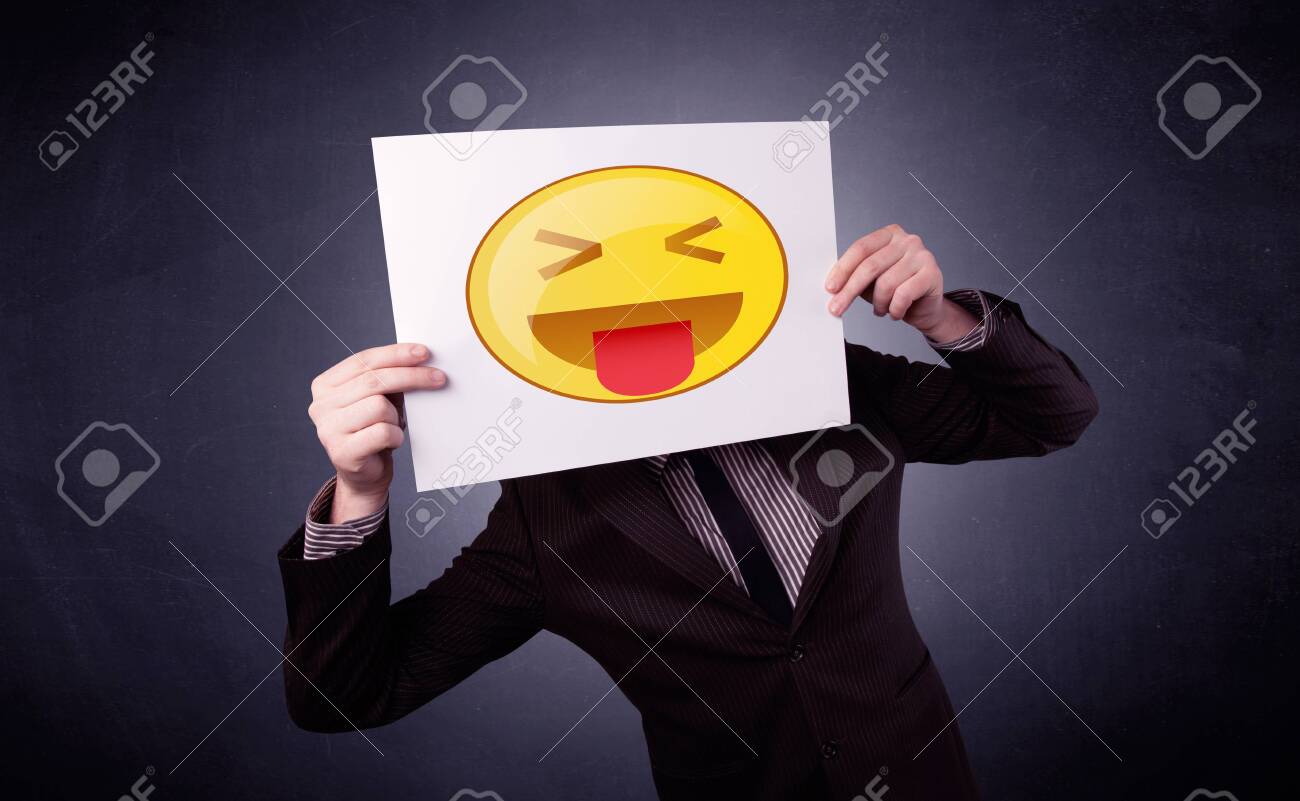段ボールで遊び心のある顔文字の後ろに隠れている青年実業家 の写真素材 画像素材 Image