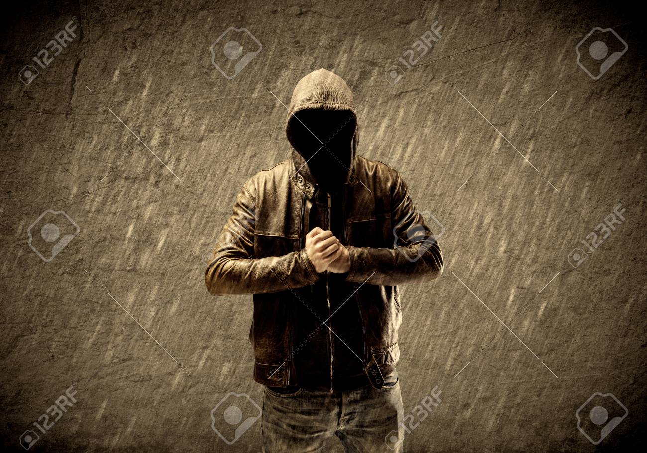 Un Extraño Hacker Confía En Pie Con Una Sudadera Con Capucha Y Una Chaqueta De Cuero Delante De Concepto De Muro De Hormigón Urbano Marrón Sepia Fotos, Retratos, Imágenes Fotografía