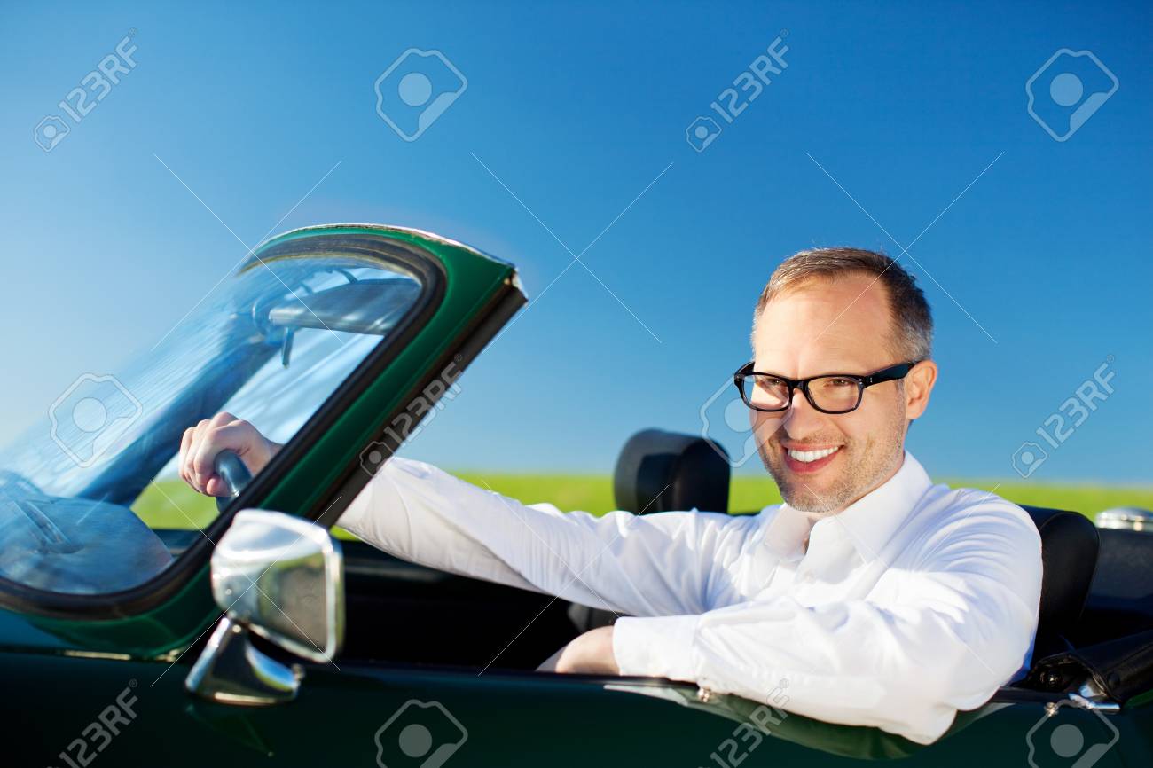 Heureux Lhomme Au Volant Dune Voiture Décapotable Sur Le Fond De Ciel Bleu - 