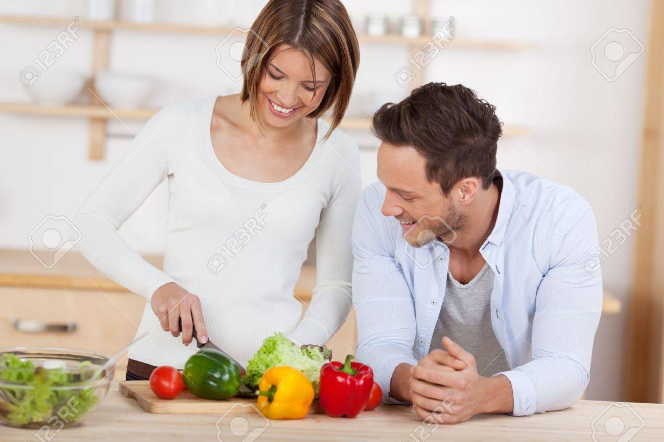 Husband and wife in their Kitchen at home preparing vegetable salad - 21162544 Husband and wife in their Kitchen at home preparing vegetable salad - 21162544