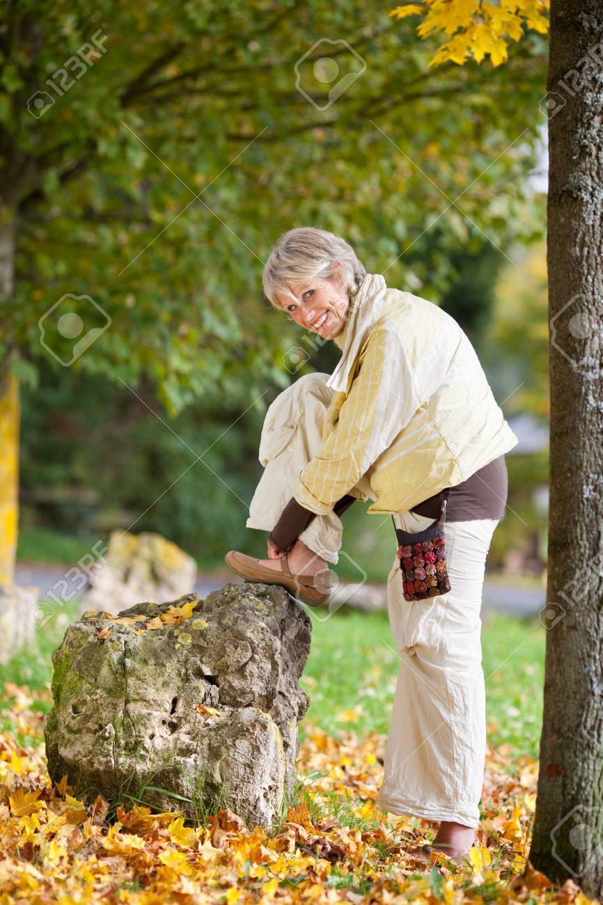 公園で秋の靴を着ている年配の女性の完全な長さ の写真素材 画像素材 Image