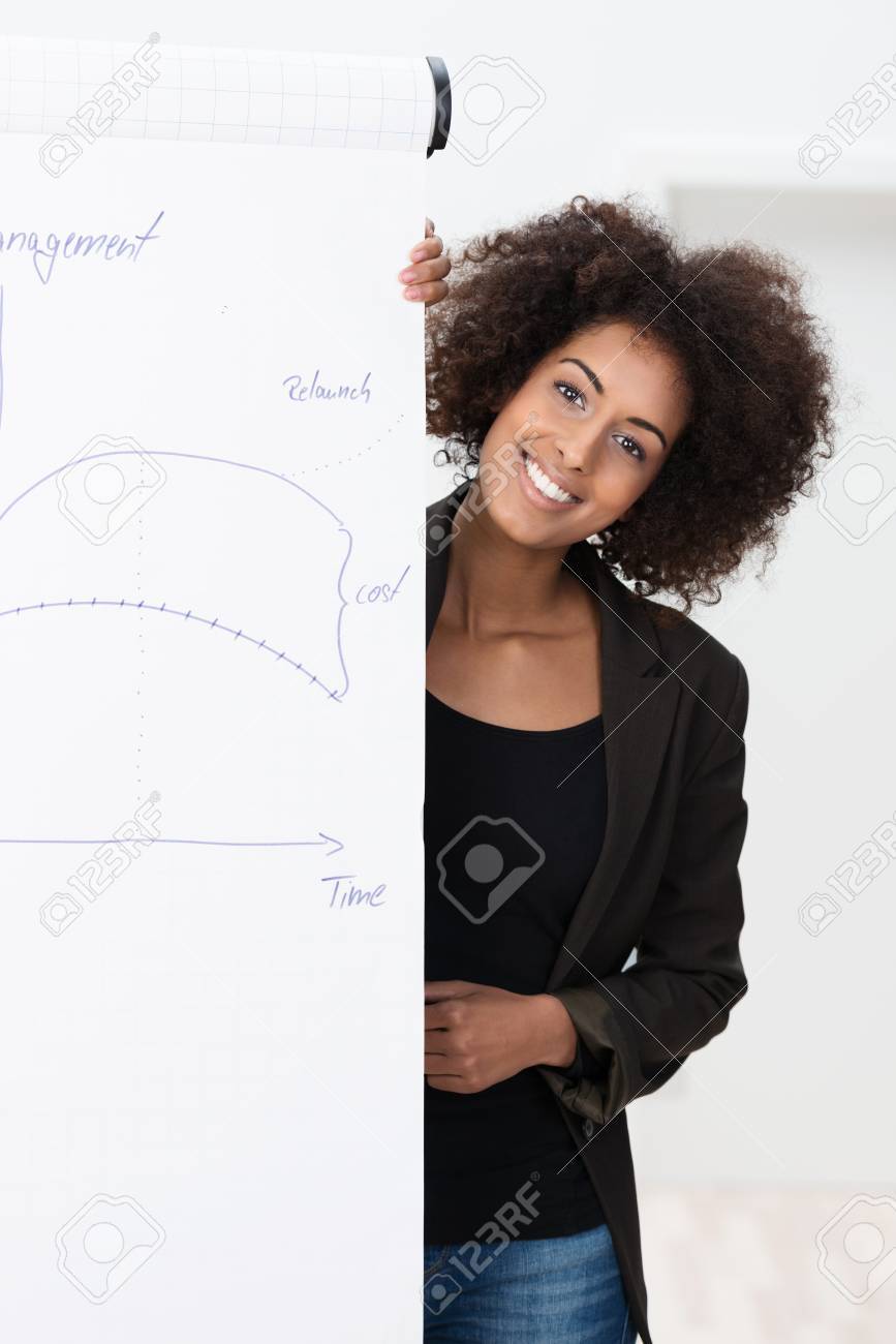 Lächelnd Zuversichtlich Junge Afroamerikaner Geschäftsfrau Mit Einem Lächelnd zuversichtlich junge Afroamerikaner geschäftsfrau mit einem Afro Frisur mit einer Präsentation oder Vorlesung stehend