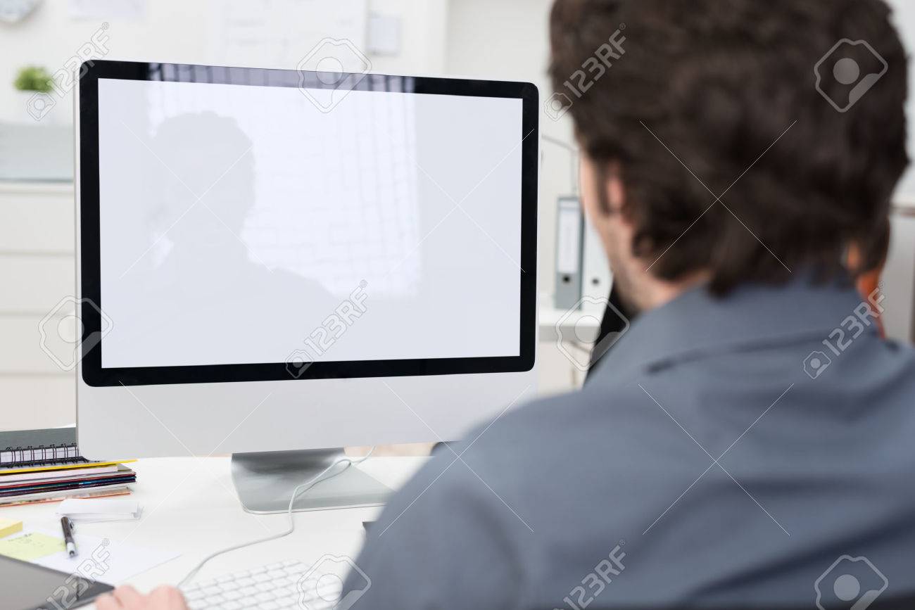 businessman using a desktop computer with a view over his shoulder