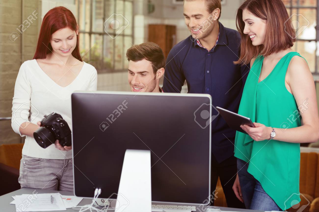 group of young friends watching photos on a dslr camera together