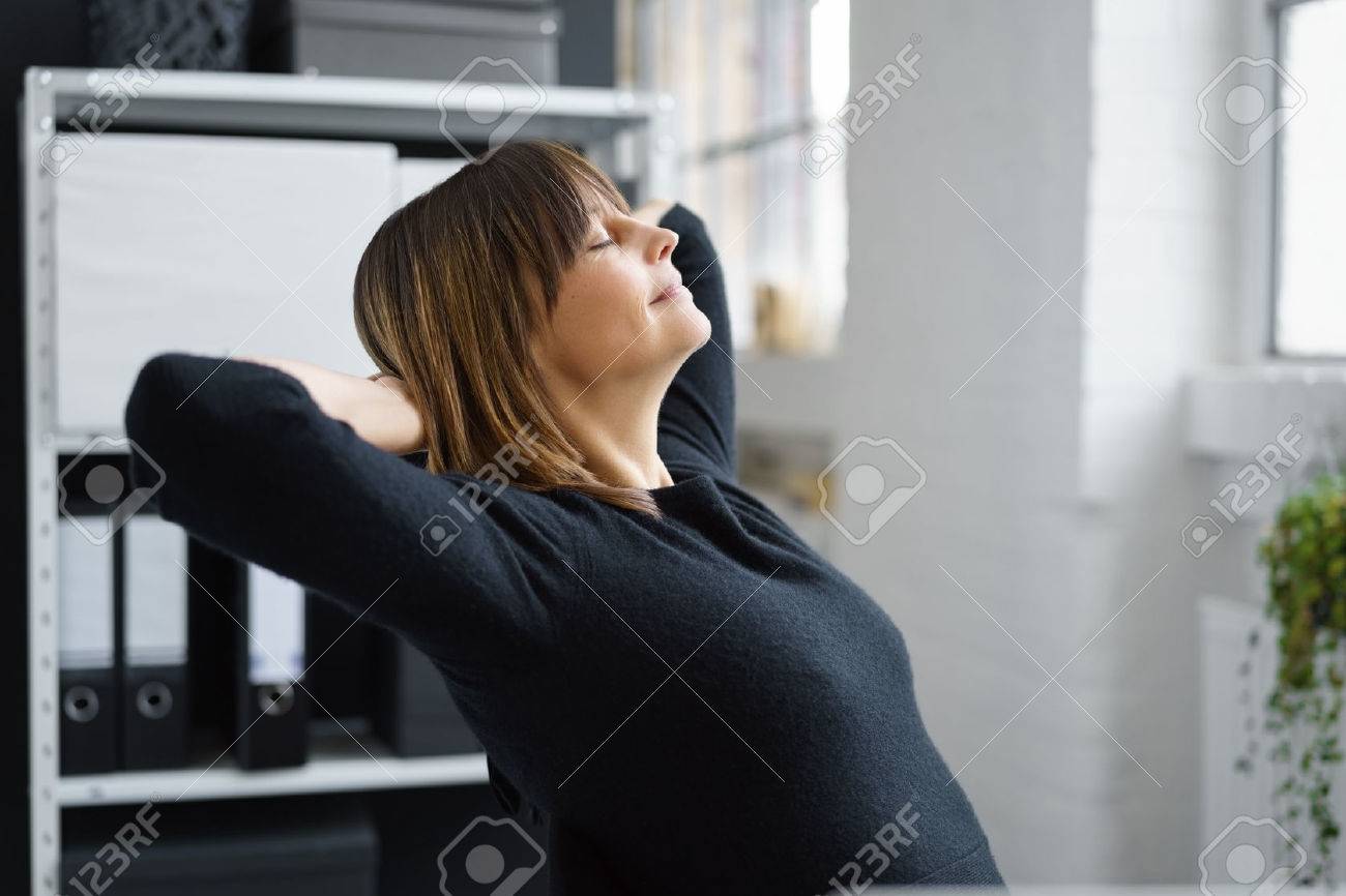 Attractive businesswoman taking a break to relax and de-stress leaning back in her chair with her eyes closed, profile view - 69584154 Attractive businesswoman taking a break to relax and de-stress leaning back in her chair with her eyes closed, profile view - 69584154