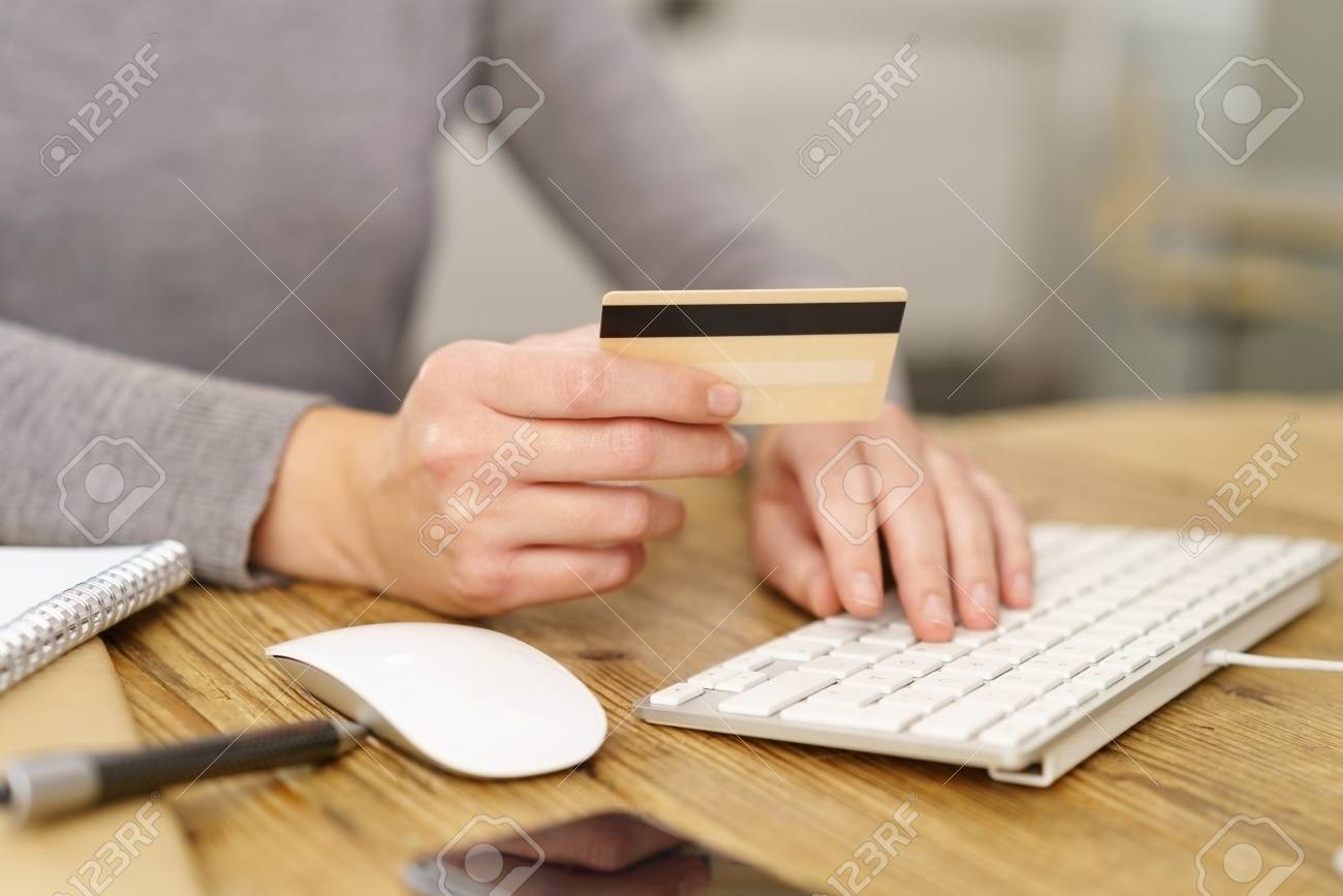 Woman making online purchases entering her bank card details as she completes her shopping - 89273563 Woman making online purchases entering her bank card details as she completes her shopping - 89273563