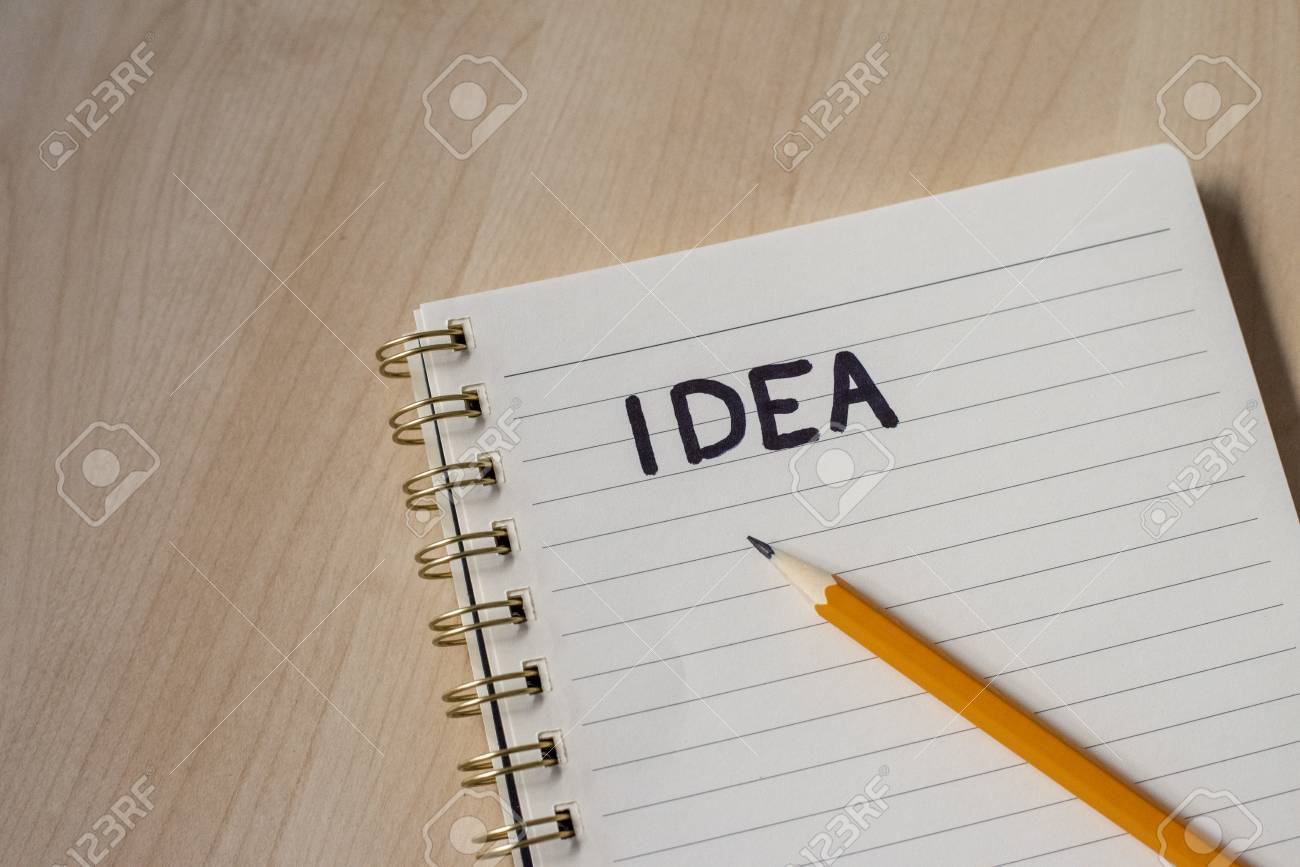 white notebook for ideas with notes and wooden desk
