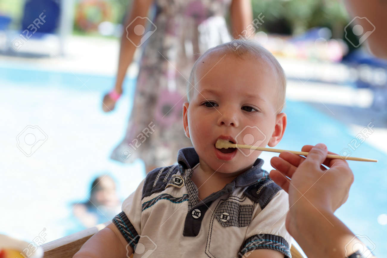 赤ちゃんはレストランで箸でお粥を食べています の写真素材 画像素材 Image