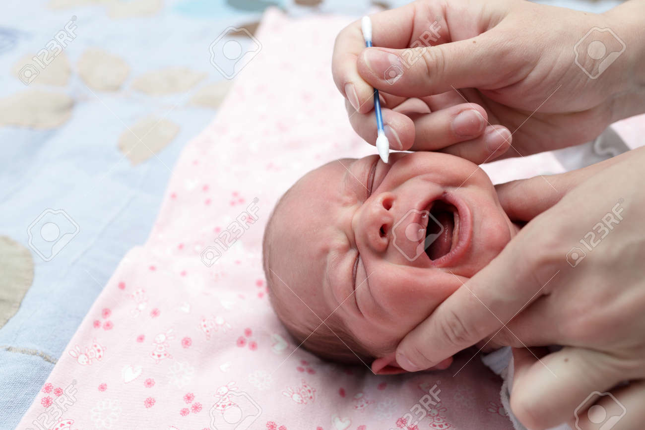 ママの赤ちゃん男の子綿棒で鼻を洗浄 の写真素材 画像素材 Image