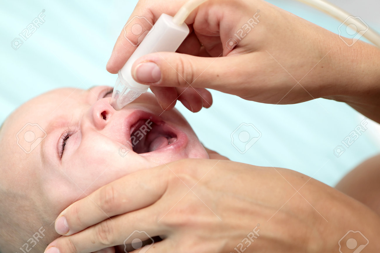 赤ちゃんの男の子のための子供の鼻水吸引器を使用しての母 の写真素材 画像素材 Image