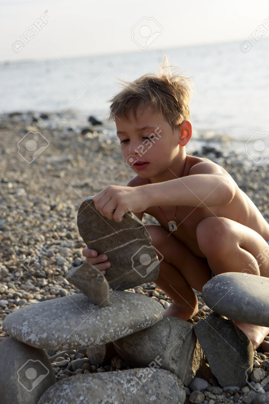 Boy Playing On Pebble Beach Of The Sea Of Azov Stock Photo, Picture and  Royalty Free Image. Image 87155219.
