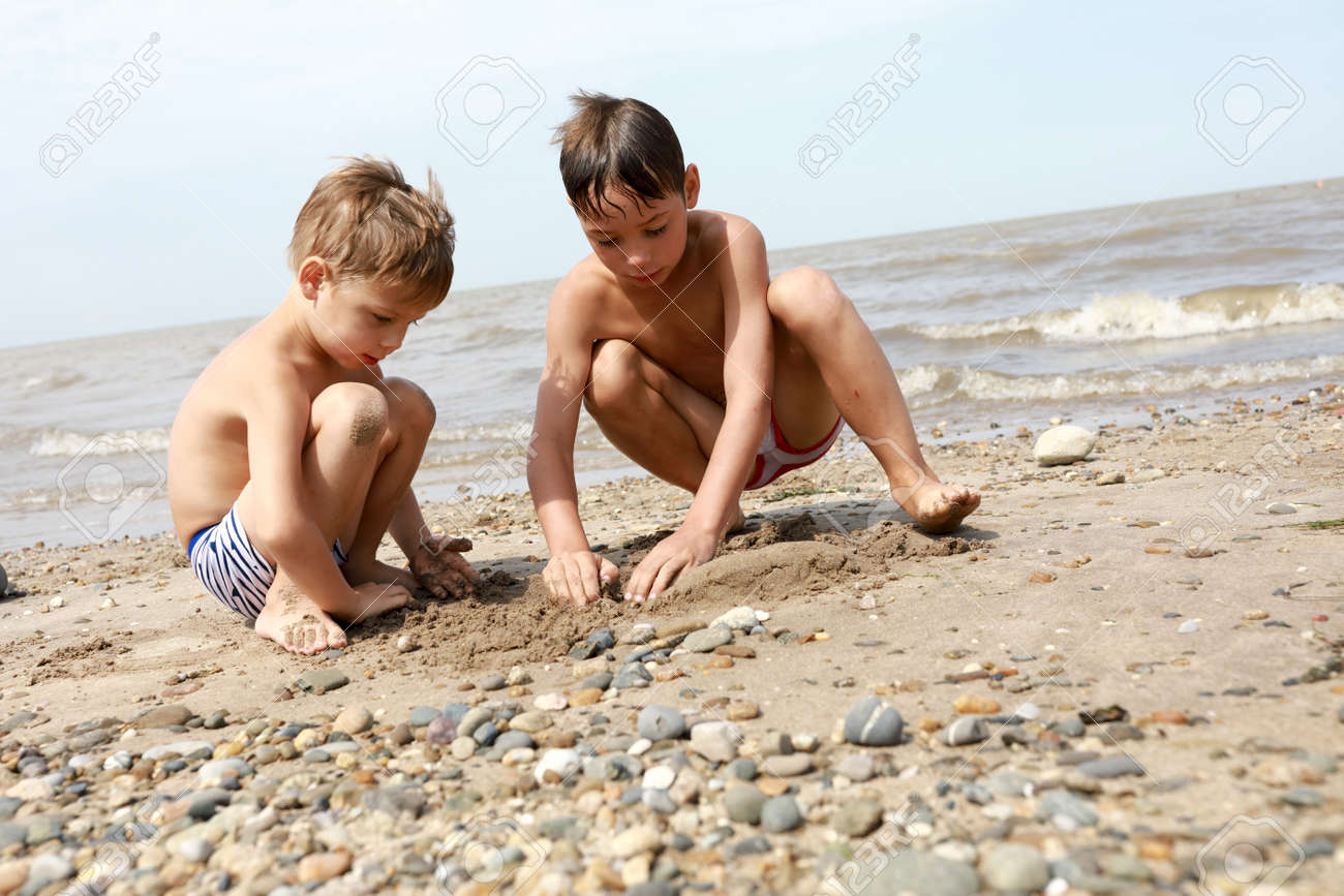 Boys Playing With Pebbles On Beach Of Sea Of Azov Stock Photo, Picture and  Royalty Free Image. Image 130444916.