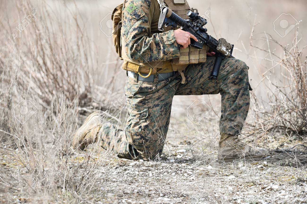 automatic rifle detail and military camouflage uniform on a soldier