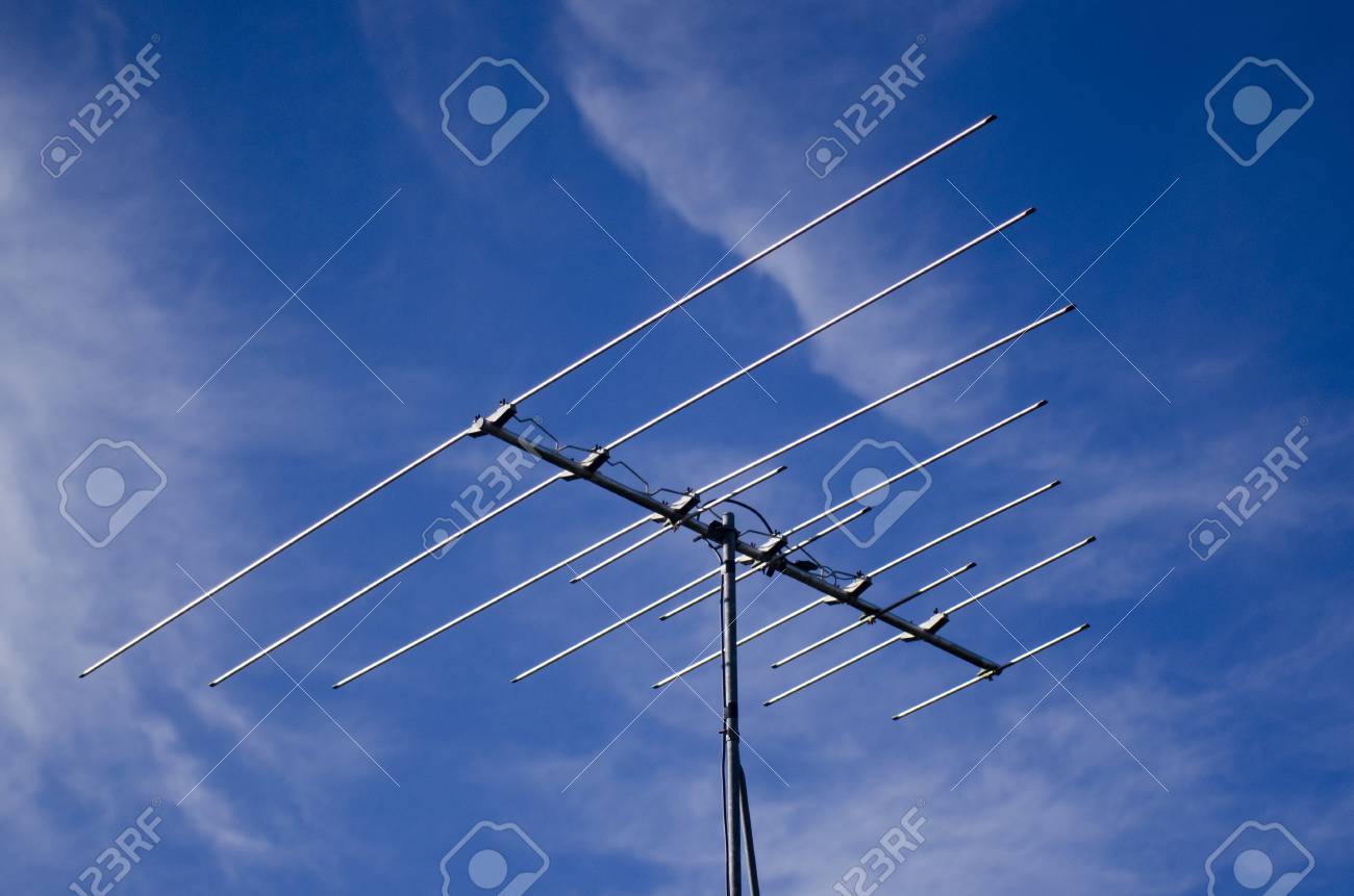 outdated analogue tv antenna against blue sky banco de imagens