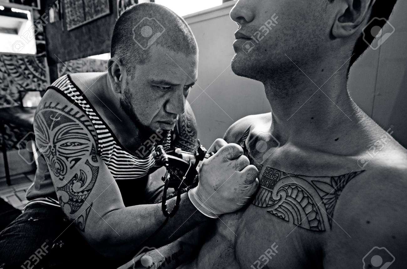 太平洋の島の男性タトゥー アーティストは 若い男がクライアントの胸にデザインを描画します 本当のタトゥー スタジオで大人 2 を人します Bw の写真素材 画像素材 Image