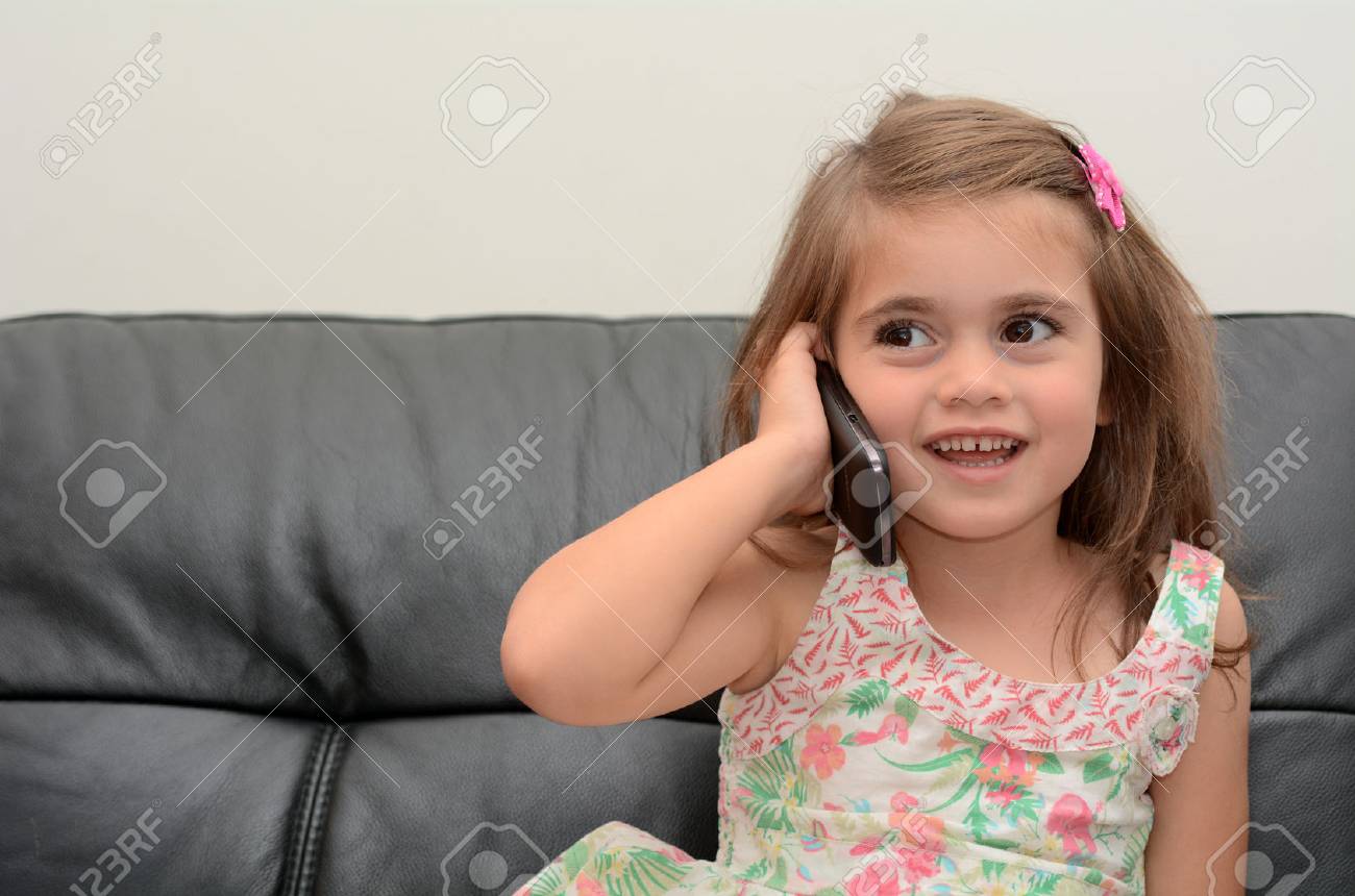 Gluckliches Kleines Madchen Spricht Am Telefon Zu Hause Konzept