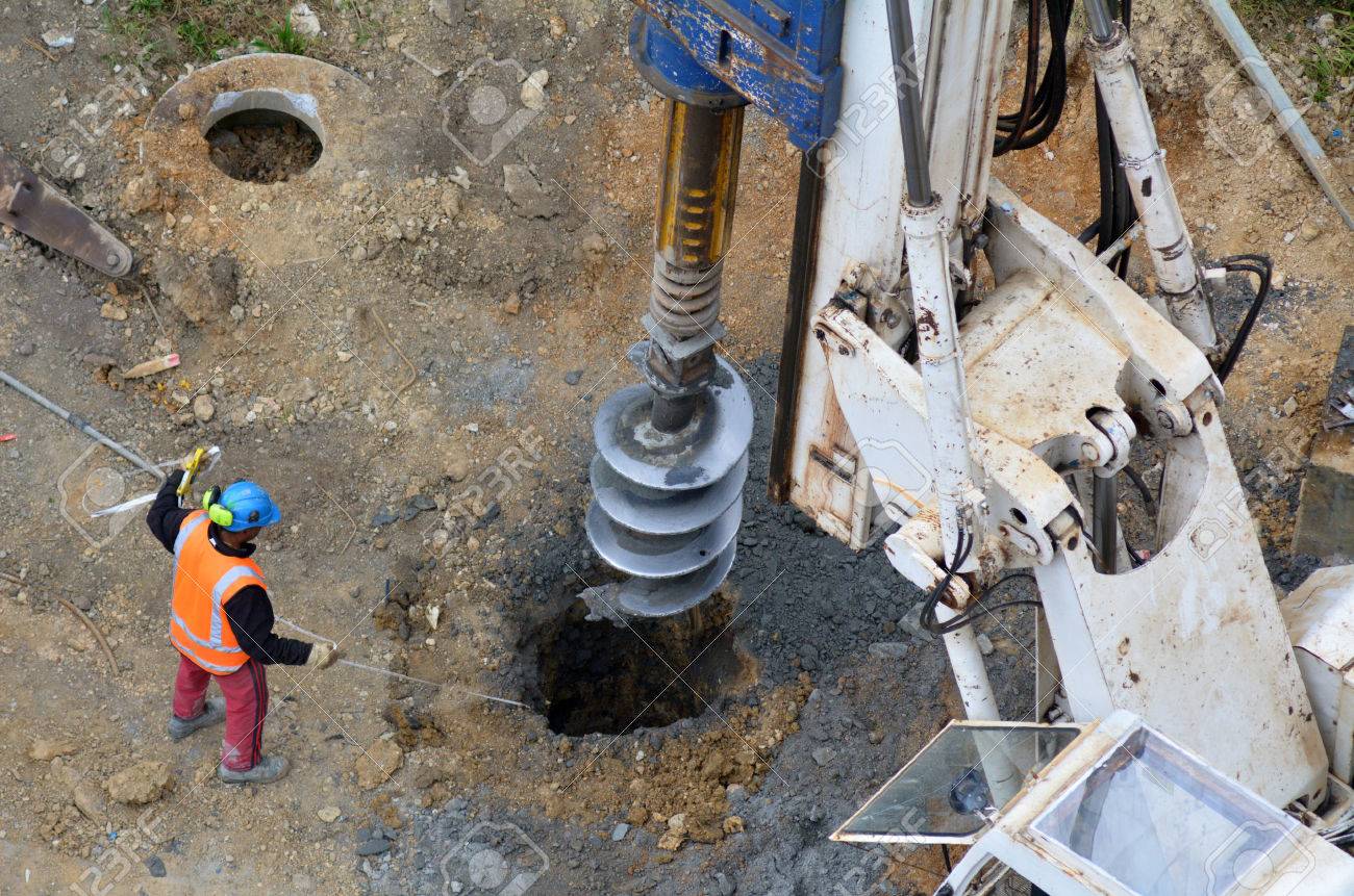 Aerial view of a worker measure the depth of a hole created by Hydraulic Hammer Drilling Machine at Construction Site. - 48521863 Aerial view of a worker measure the depth of a hole created by Hydraulic Hammer Drilling Machine at Construction Site. - 48521863