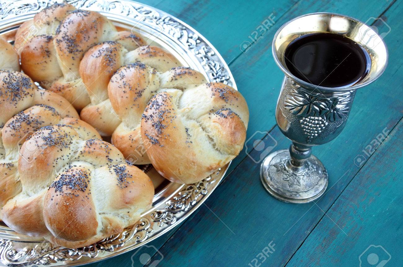 Overhead view of Shabbat eve table with uncovered challah bread and Kiddush wine cup. - 62201370 Overhead view of Shabbat eve table with uncovered challah bread and Kiddush wine cup. - 62201370