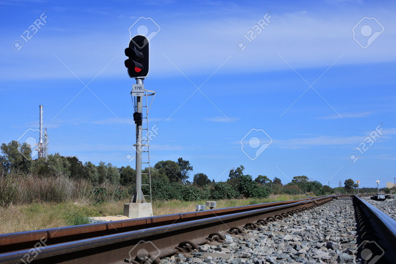 Railway signal on an empty rail way track near industrial site. No people. Copy space - 168379561 Railway signal on an empty rail way track near industrial site. No people. Copy space - 168379561