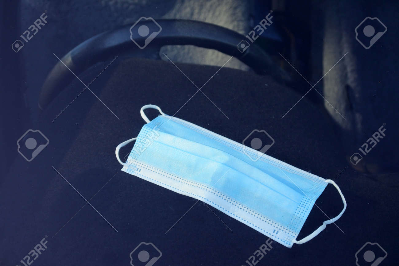 One medical face mask left on car dashboard. - 169904533 One medical face mask left on car dashboard. - 169904533