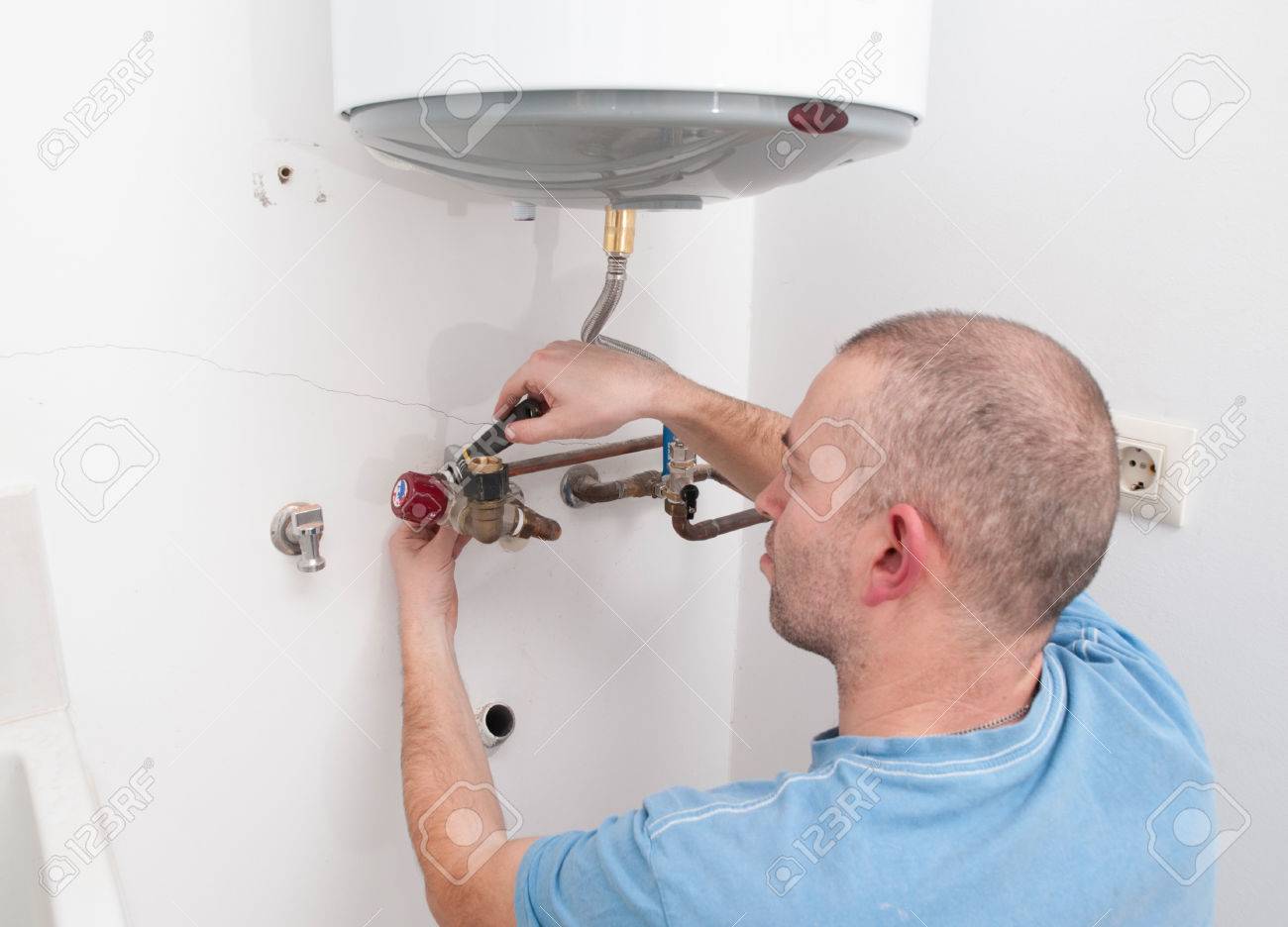 Plumber repairing an electric boiler inside home - 24438440 Plumber repairing an electric boiler inside home - 24438440