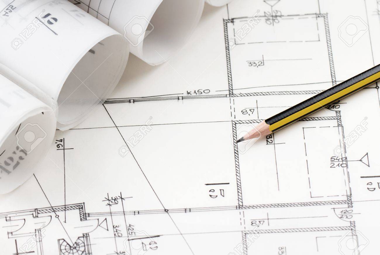 close up of yellow pencil over architectural drawings stock photo