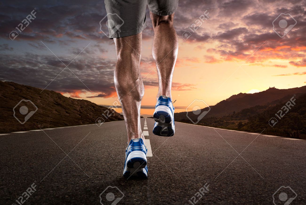 Close up of athlete running on the empty road at the sunset - 31399850 Close up of athlete running on the empty road at the sunset - 31399850