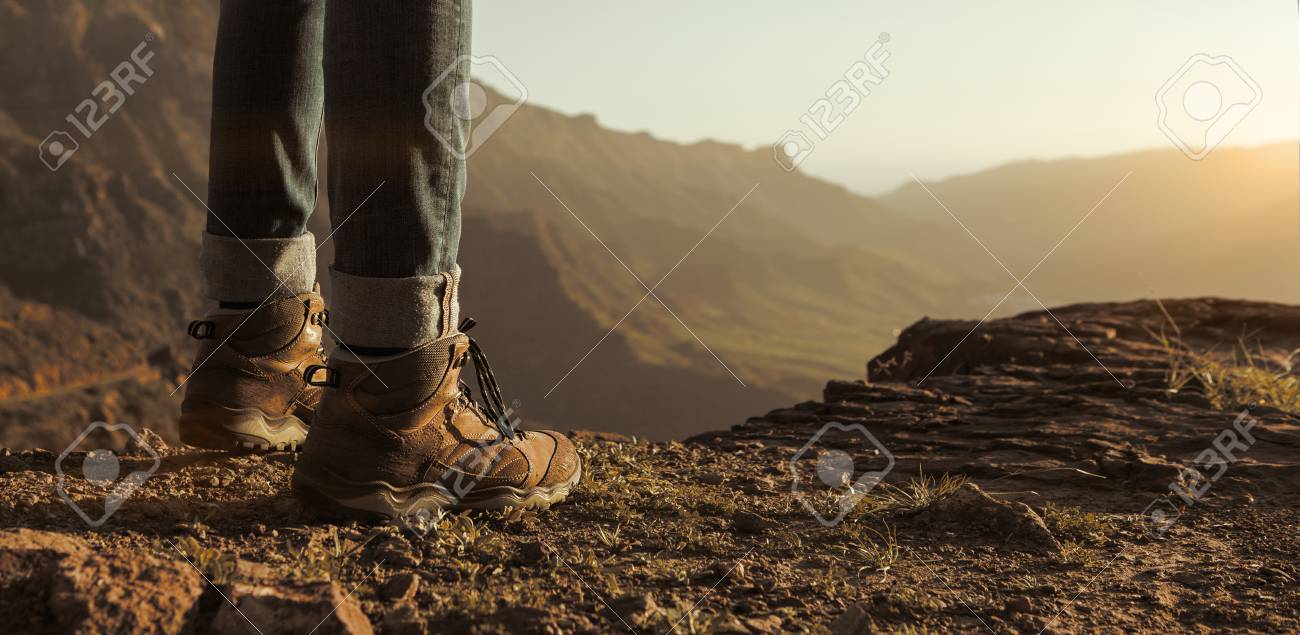 Close up of hikers boots enjoying the sunset in the mountains with copy space - 101770825 Close up of hikers boots enjoying the sunset in the mountains with copy space - 101770825