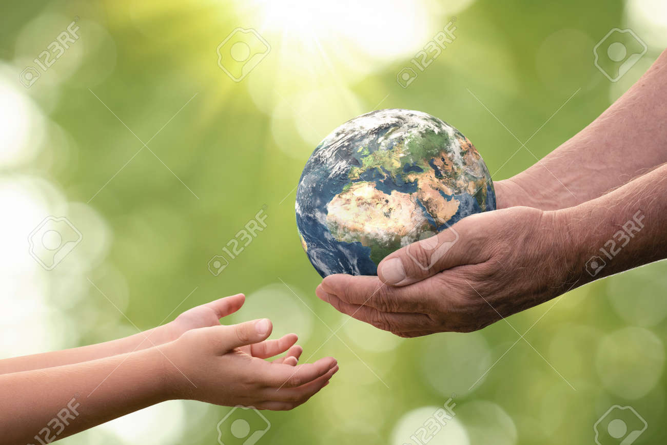 Close up of senior hands giving small planet earth to a child over defocused green background with copy space - 165211735 Close up of senior hands giving small planet earth to a child over defocused green background with copy space - 165211735