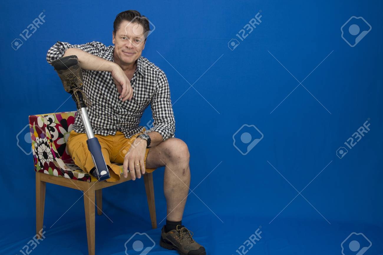 Middle-aged man with physical disability, happy with life sitting on the chair - 96380831 Middle-aged man with physical disability, happy with life sitting on the chair - 96380831