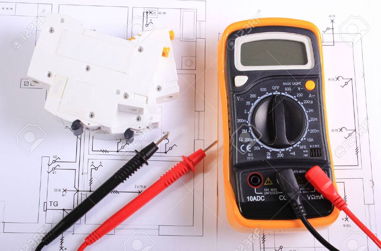 multimeter with cables and electric fuse lying on construction drawing of house electrical drawings and multimeter with cables and electric fuse lying on construction drawing of house electrical drawings and