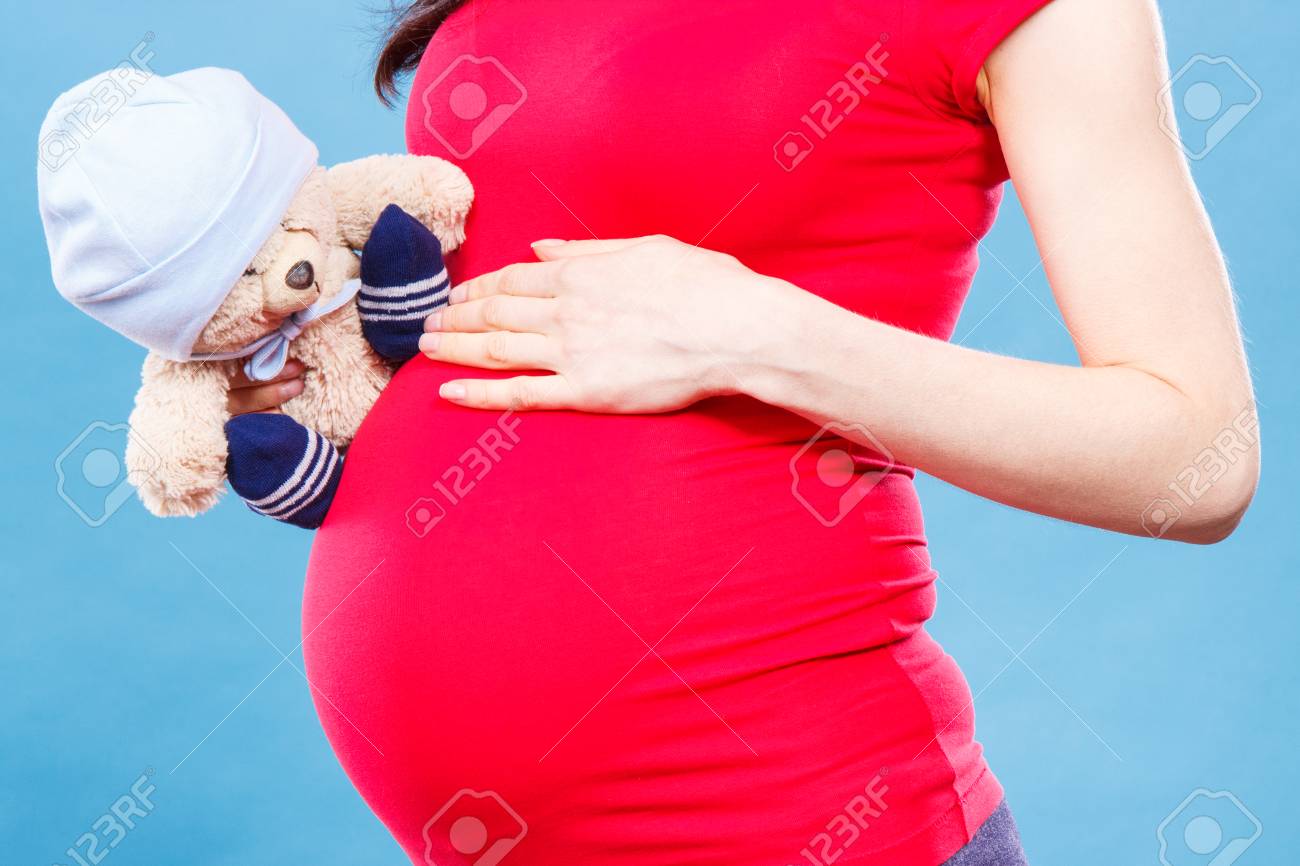 彼女のおなかの赤ちゃんを期待して ファミリーの概念をふわふわグッズ テディベアを保持している妊娠中の女性 の写真素材 画像素材 Image