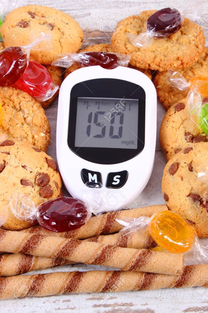 Glucometer 測定血糖値やクッキーとカラフルなキャンディーの悪い結果 糖尿病 健康的なライフ スタイル お菓子を食べて削減の概念 の写真素材 画像素材 Image