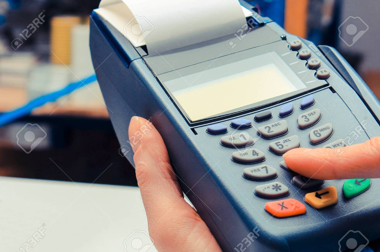 Hand of woman using payment terminal in electrical shop, paying with credit card, enter personal identification number - 128761241 Hand of woman using payment terminal in electrical shop, paying with credit card, enter personal identification number - 128761241