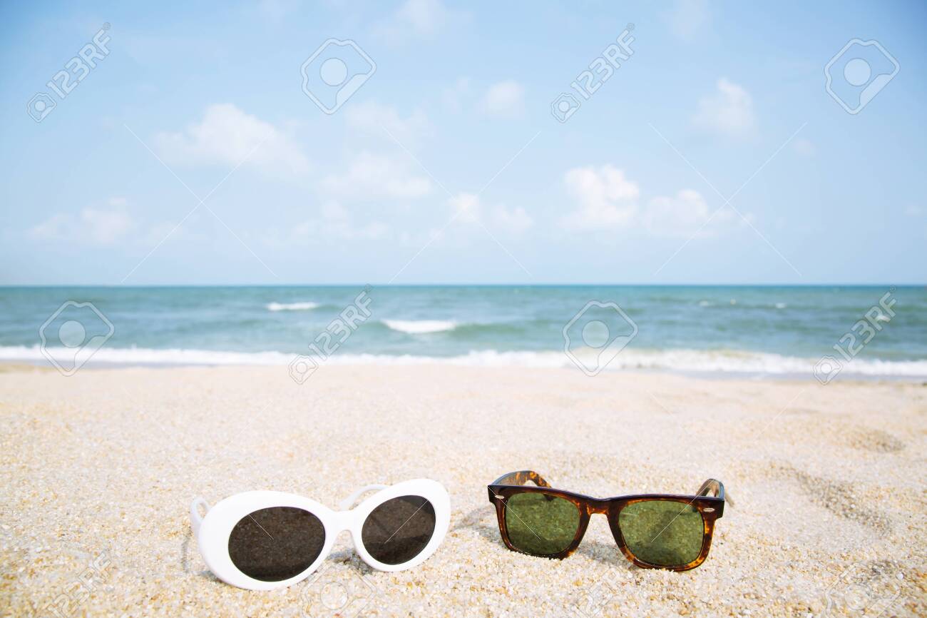 Two Fashion Sunglasses Close Up On The Beach Sand In Summer Beautiful Sea View Clear Blue Sky Wallpaper Summer Holiday Relax Background With Copy Space Sunglasses Travel Couple Lovers Concept Stock Photo