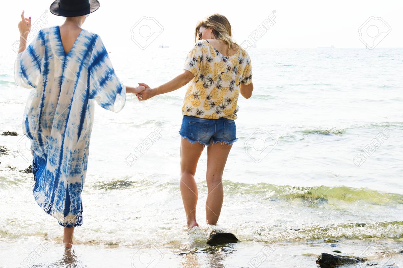 girlfriends holding hands and walking on the beach foto royalty free