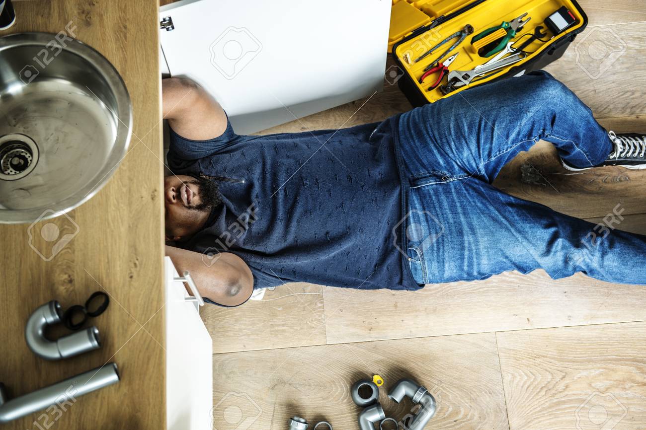 Man fixing kitchen sink - 98004846 Man fixing kitchen sink - 98004846