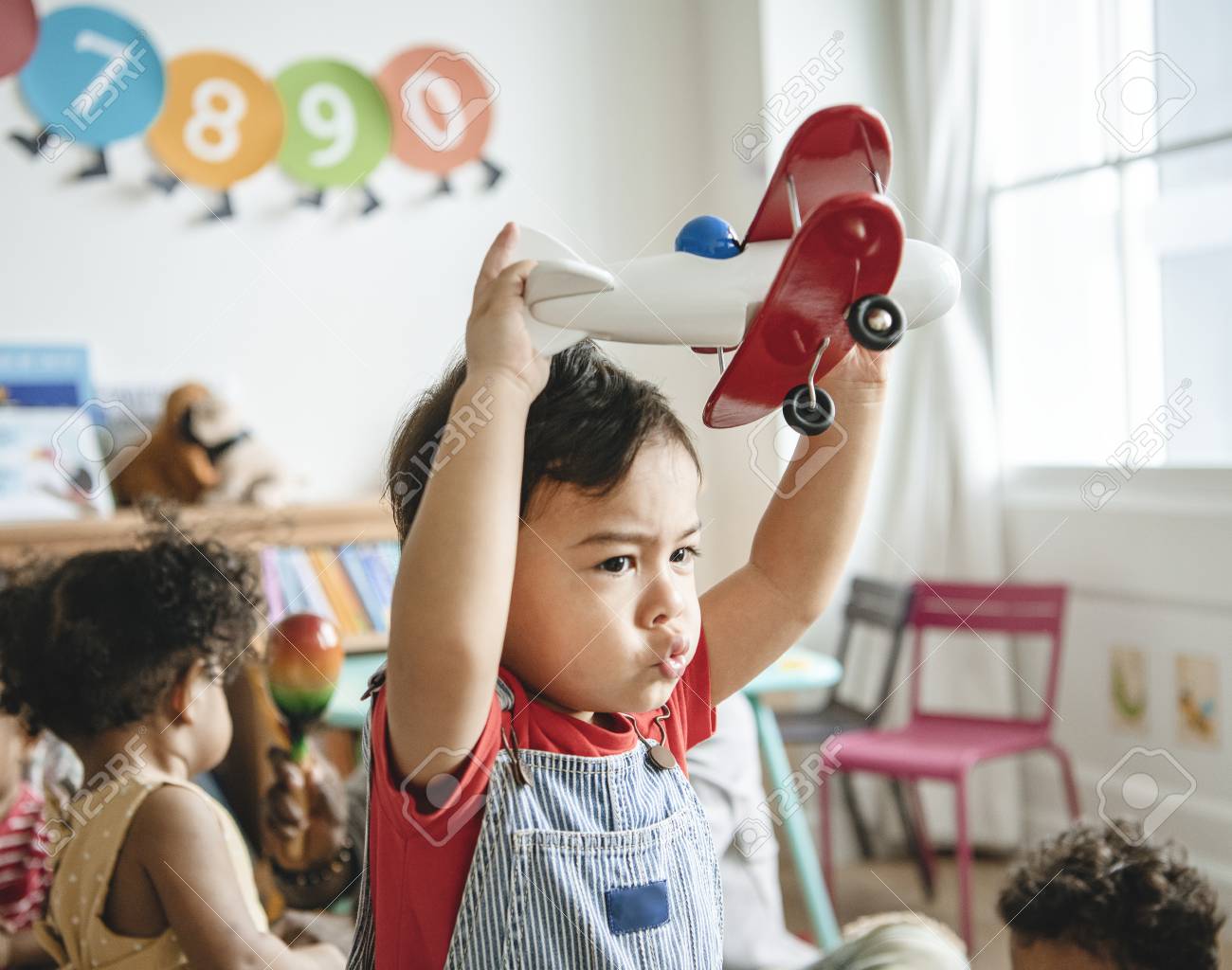 Preschooler enjoying playing with his airplane toy - 116689690 Preschooler enjoying playing with his airplane toy - 116689690