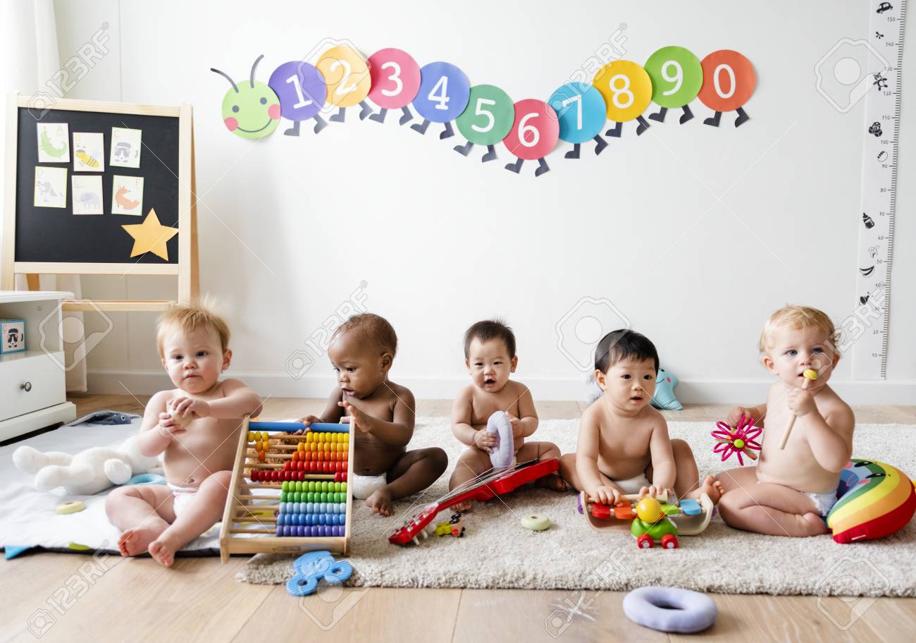 Babies playing together in a play room - 117116074 Babies playing together in a play room - 117116074