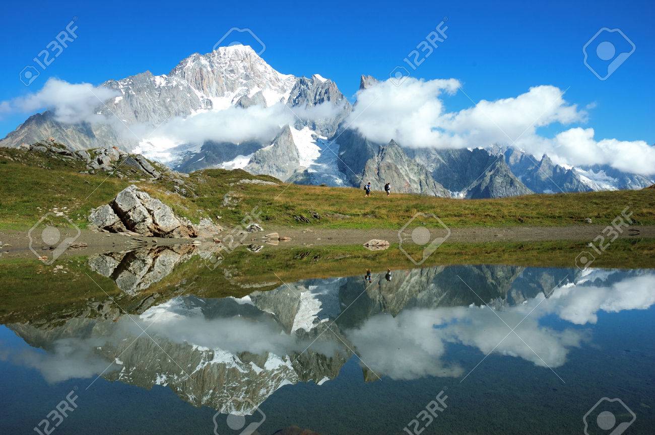 Vue De La Face Sud Du Mont Blanc Chaîne De Montagnes Reflète Dans Un Lac Tandis Que Deux Randonneurs à Pied Le Long De La Voie Val Veny En Italie
