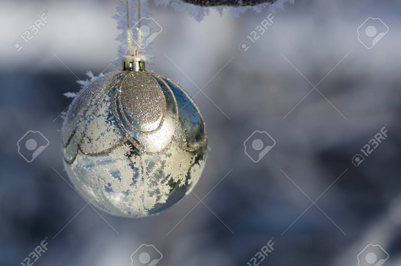 frozen golden christmas ornament decorating a snowy outdoor tree frozen christmas decorations