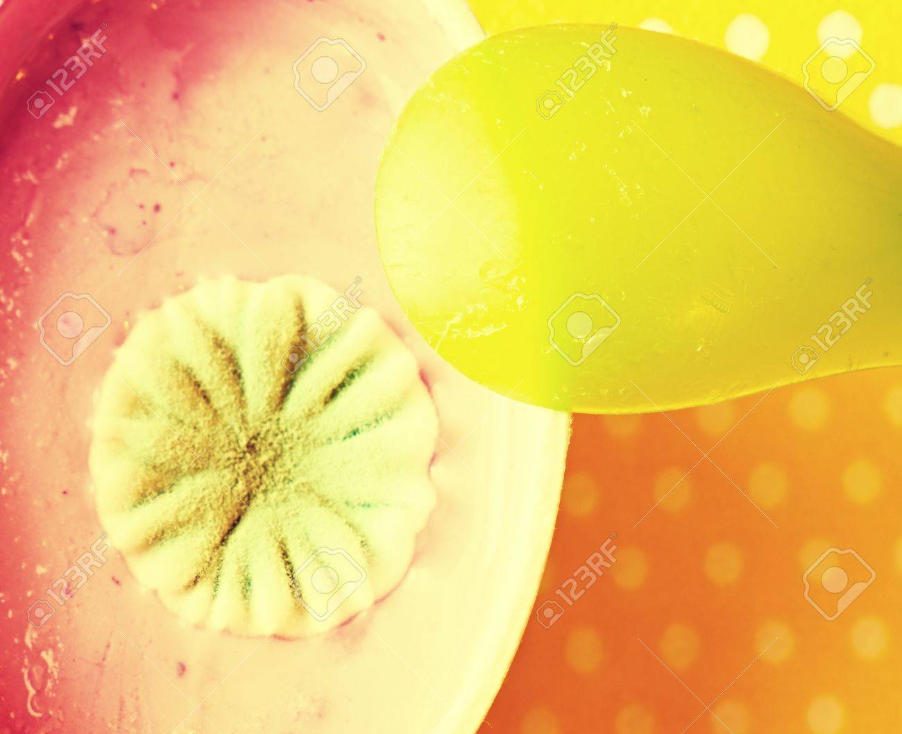 毒カビのピンクの醜いサークル花とフルーツ ヨーグルトのプラスチック製のカップ 黄色緑プラスチック スプーン の写真素材 画像素材 Image