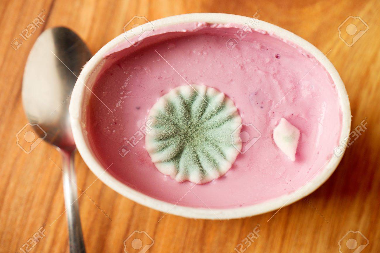 毒カビのピンクの醜いサークル花とフルーツ ヨーグルトのプラスチック製のカップ ステンレスのスプーン の写真素材 画像素材 Image